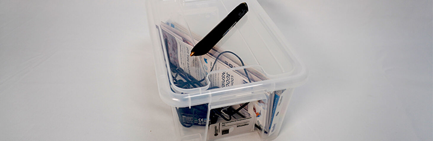 a transparent box filled with wires and flyers