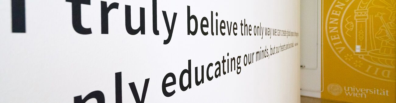 Gang am Zentrum für Lehrer*innenbildung mit einem Universität Wien Logo an der Wand 